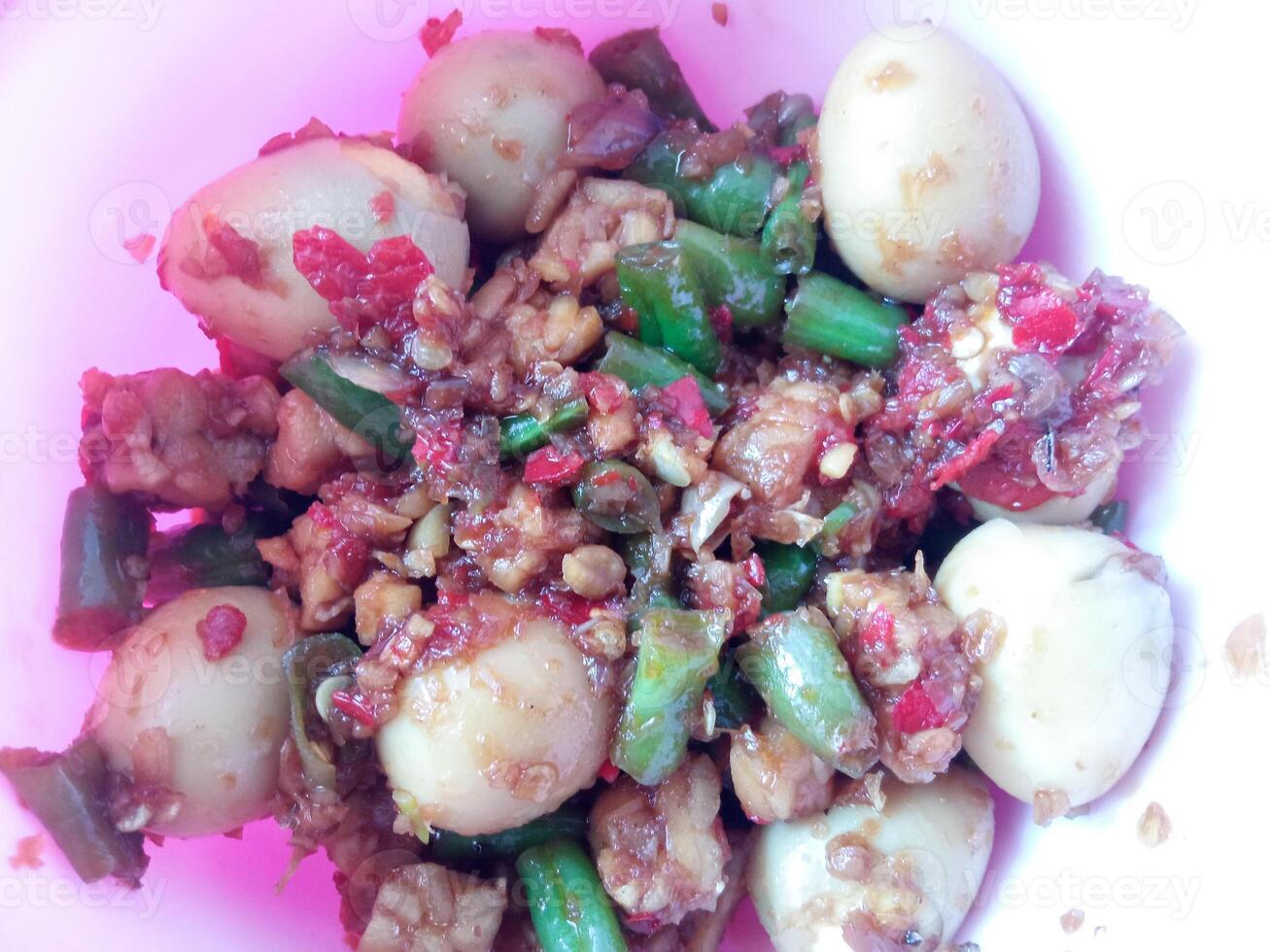 a bowl of balado quail eggs and tempeh ready to eat isolate on white photo