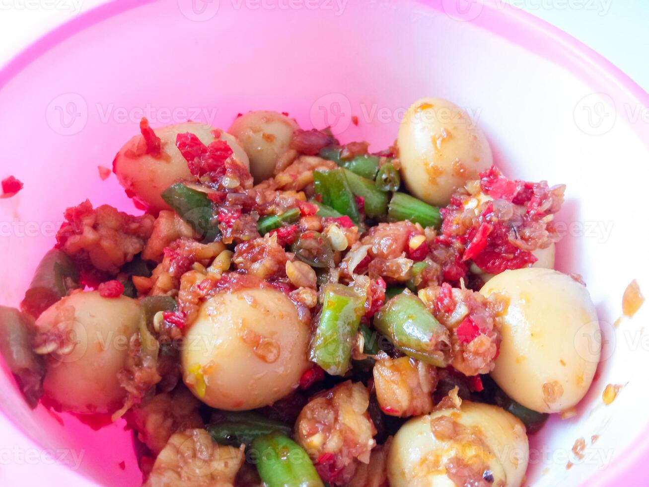 a bowl of balado quail eggs and tempeh ready to eat isolate on white photo
