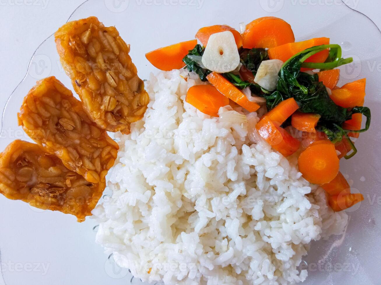 a plate of rice with tempeh and vegetables ready to eat isolate on white photo