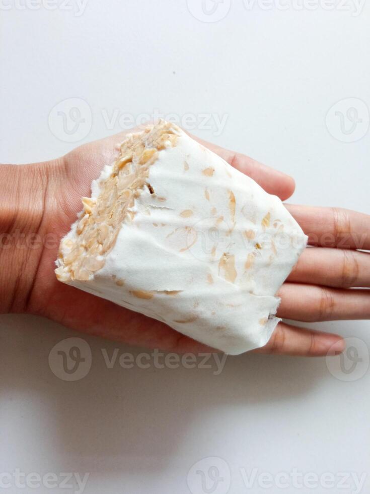 Traditional Indonesian food is tempeh placed in the hand photo