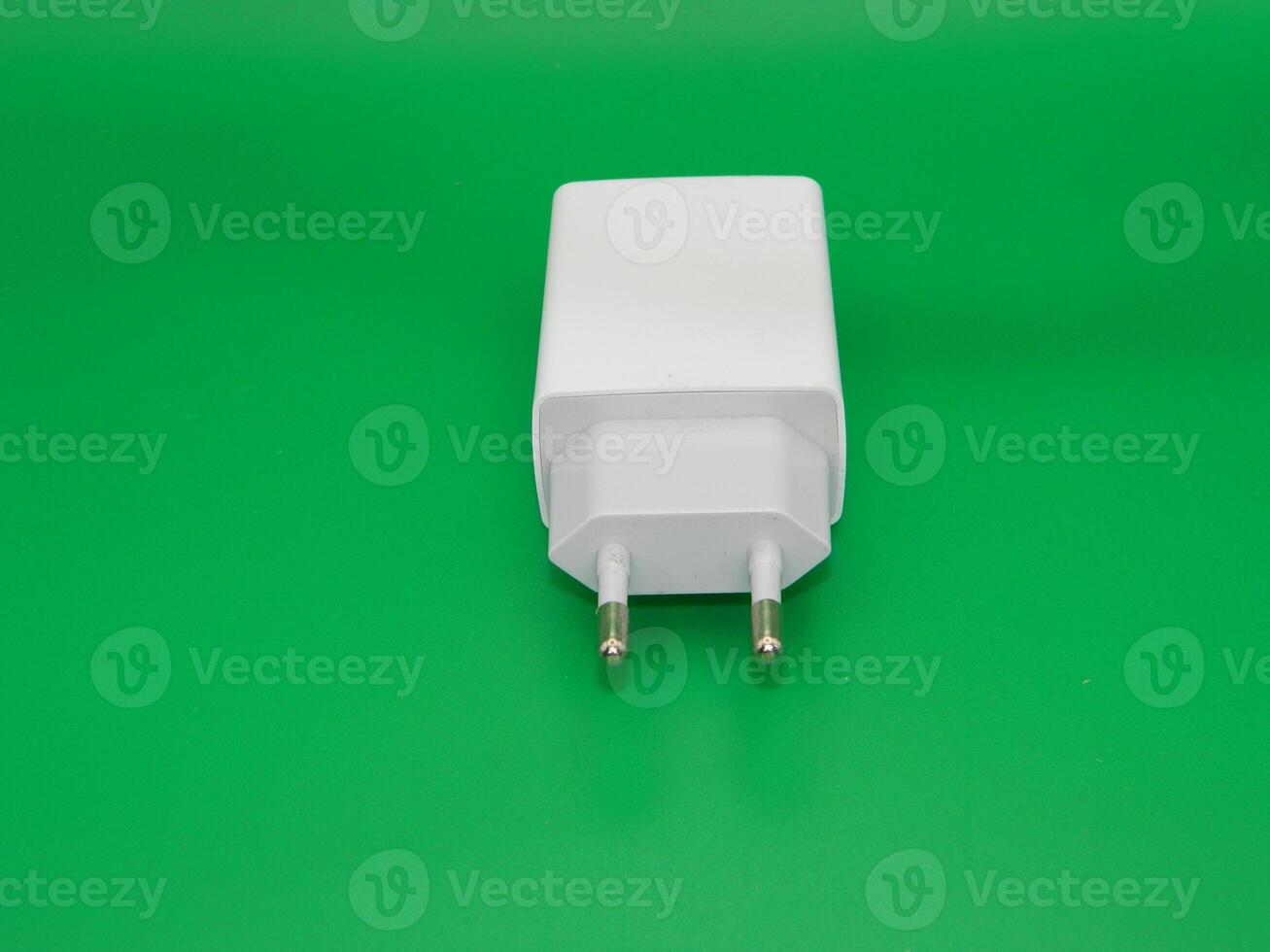 Macro photo of the white charging head on a green background. Usually use for smartphone