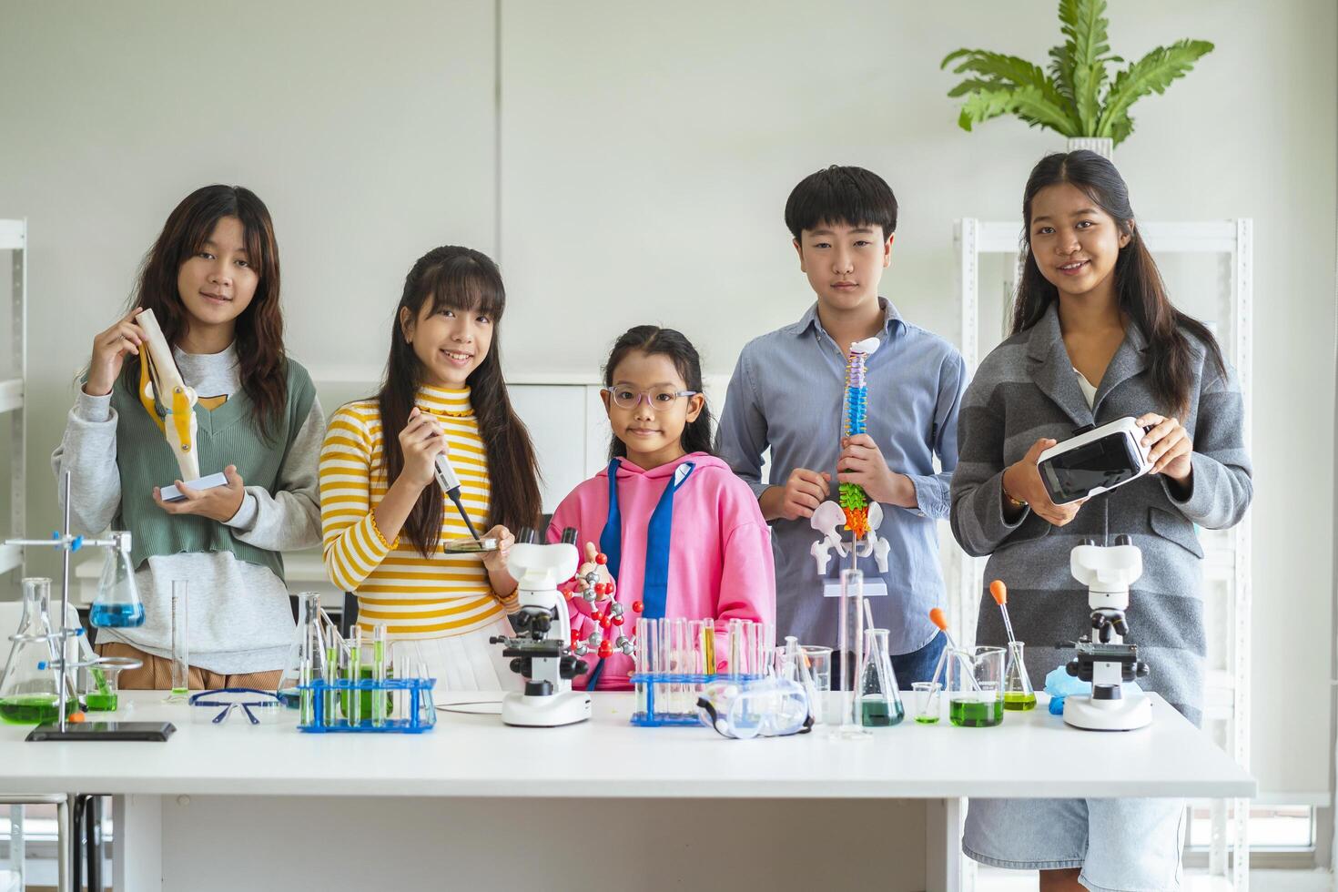 Group of children doing chemistry experiments for classroom learning photo