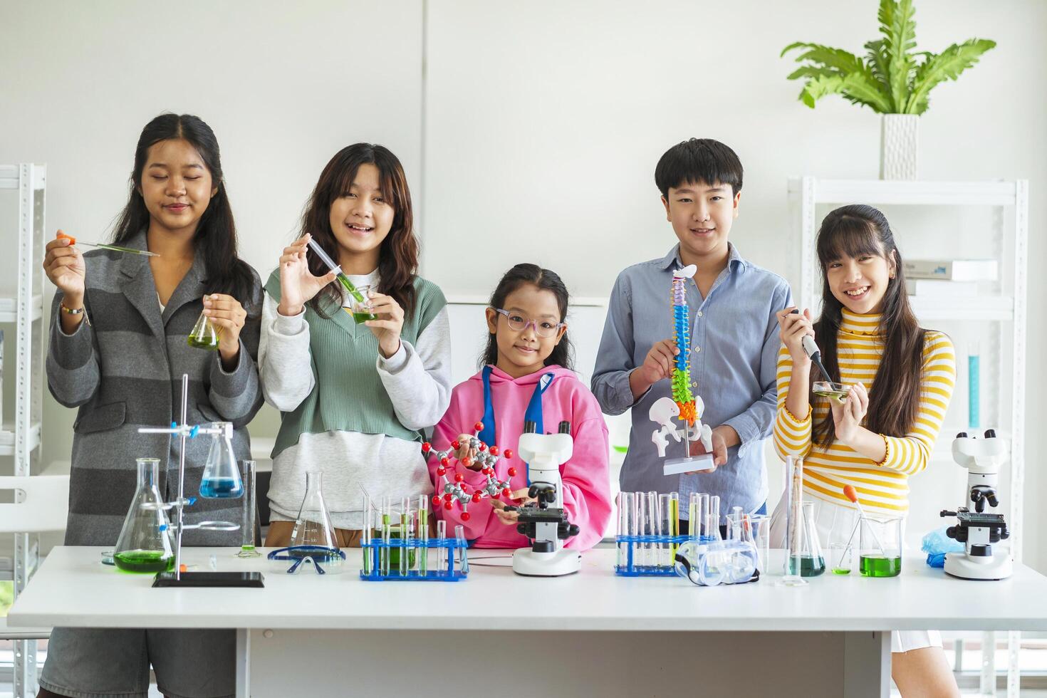 Group of children doing chemistry experiments for classroom learning photo
