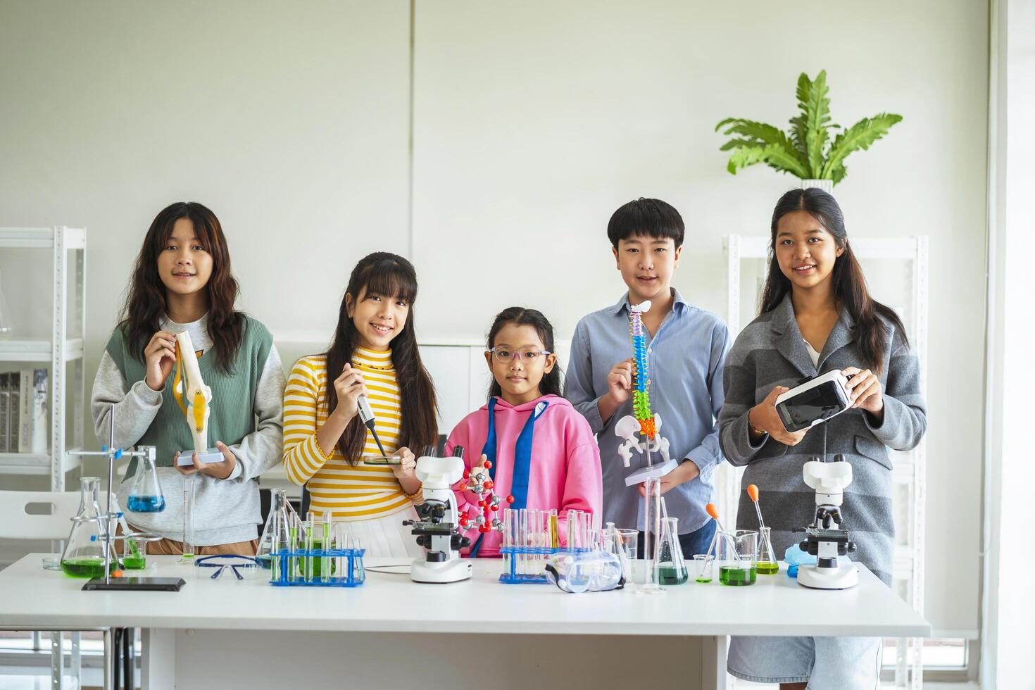 Group of children doing chemistry experiments for classroom learning photo
