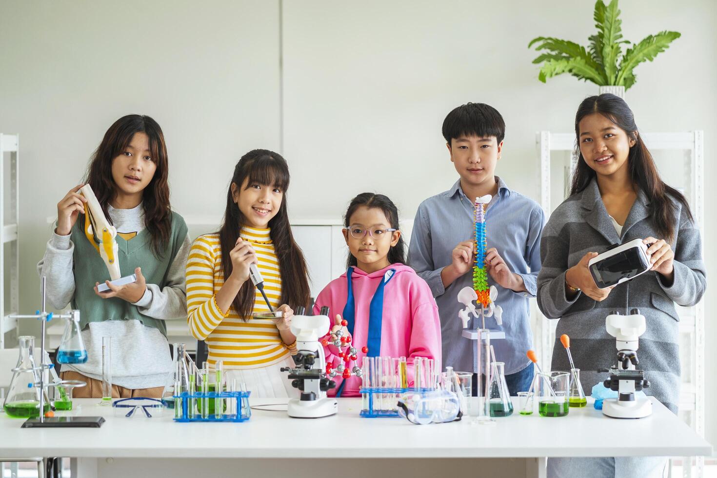 Group of children doing chemistry experiments for classroom learning photo