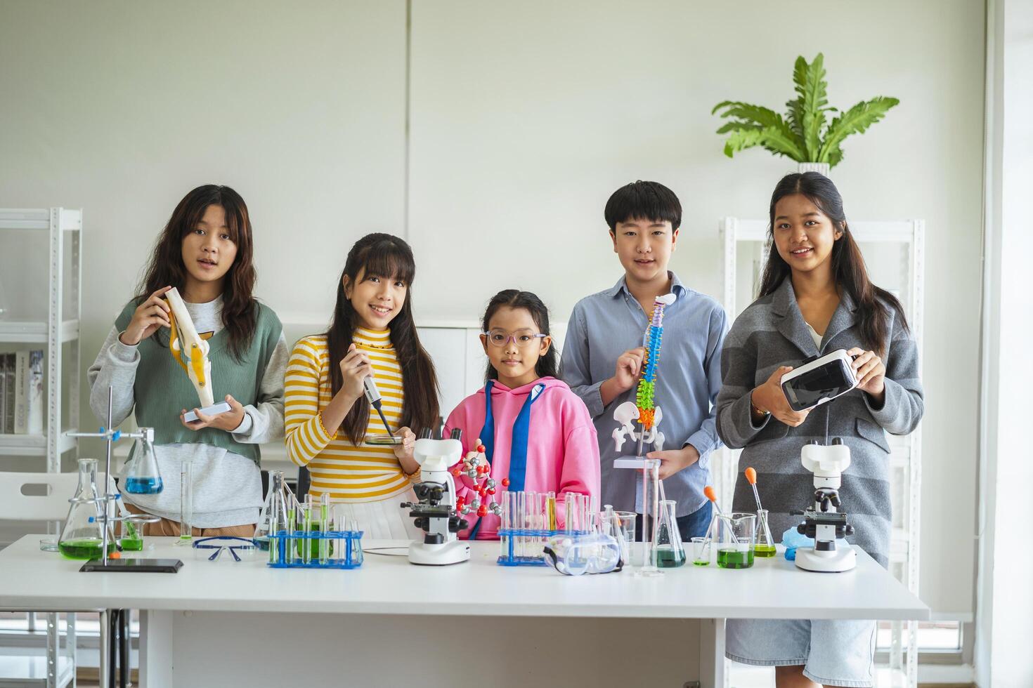Group of children doing chemistry experiments for classroom learning photo