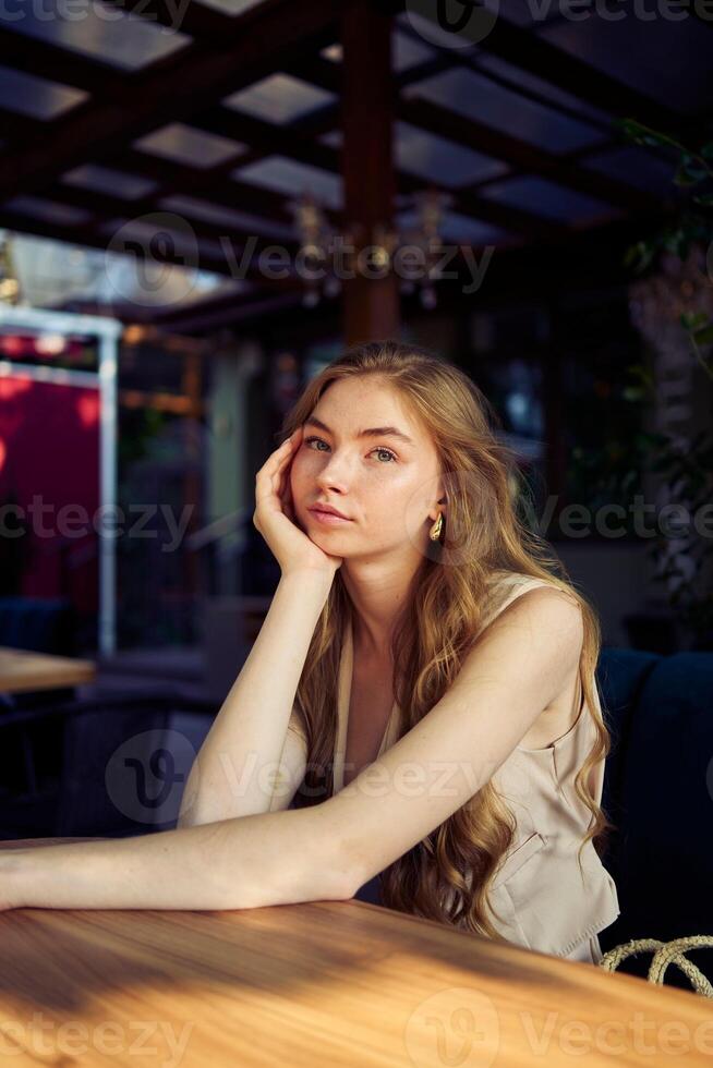 a beautiful teenage girl in a peach fuzz suit with a vest, in the old money style in a fancy restaurant photo