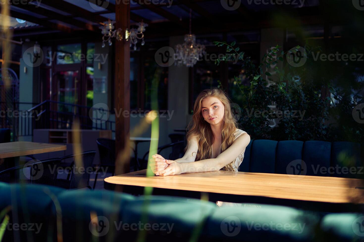 a beautiful teenage girl in a peach fuzz suit with a vest, in the old money style in a fancy restaurant photo
