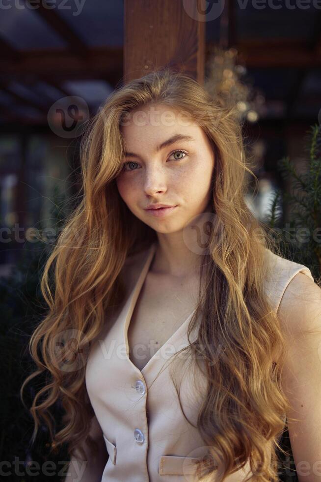 a beautiful teenage girl in a peach fuzz suit with a vest, in the old money style in a fancy restaurant photo