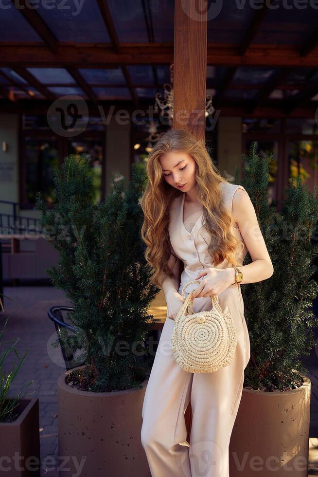 a beautiful teenage girl in a peach fuzz suit with a vest, in the old money style in a fancy restaurant photo