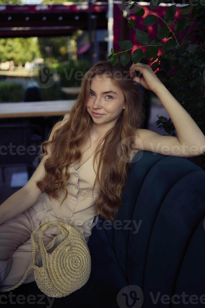 a beautiful teenage girl in a peach fuzz suit with a vest, in the old money style in a fancy restaurant photo