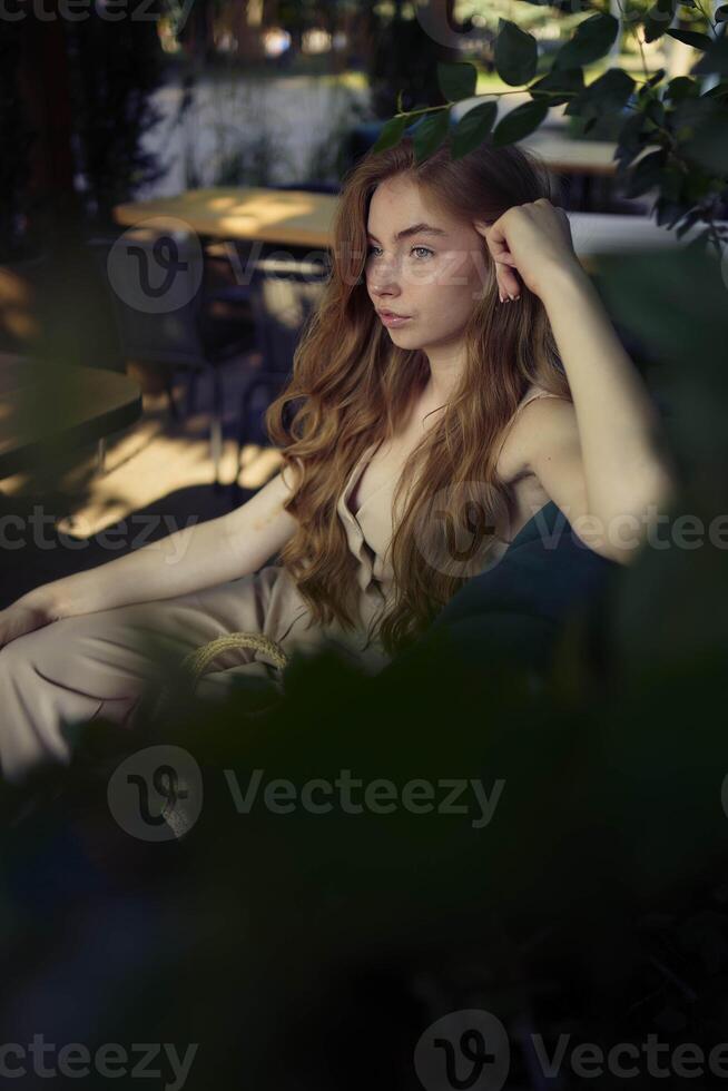 a beautiful teenage girl in a peach fuzz suit with a vest, in the old money style in a fancy restaurant photo