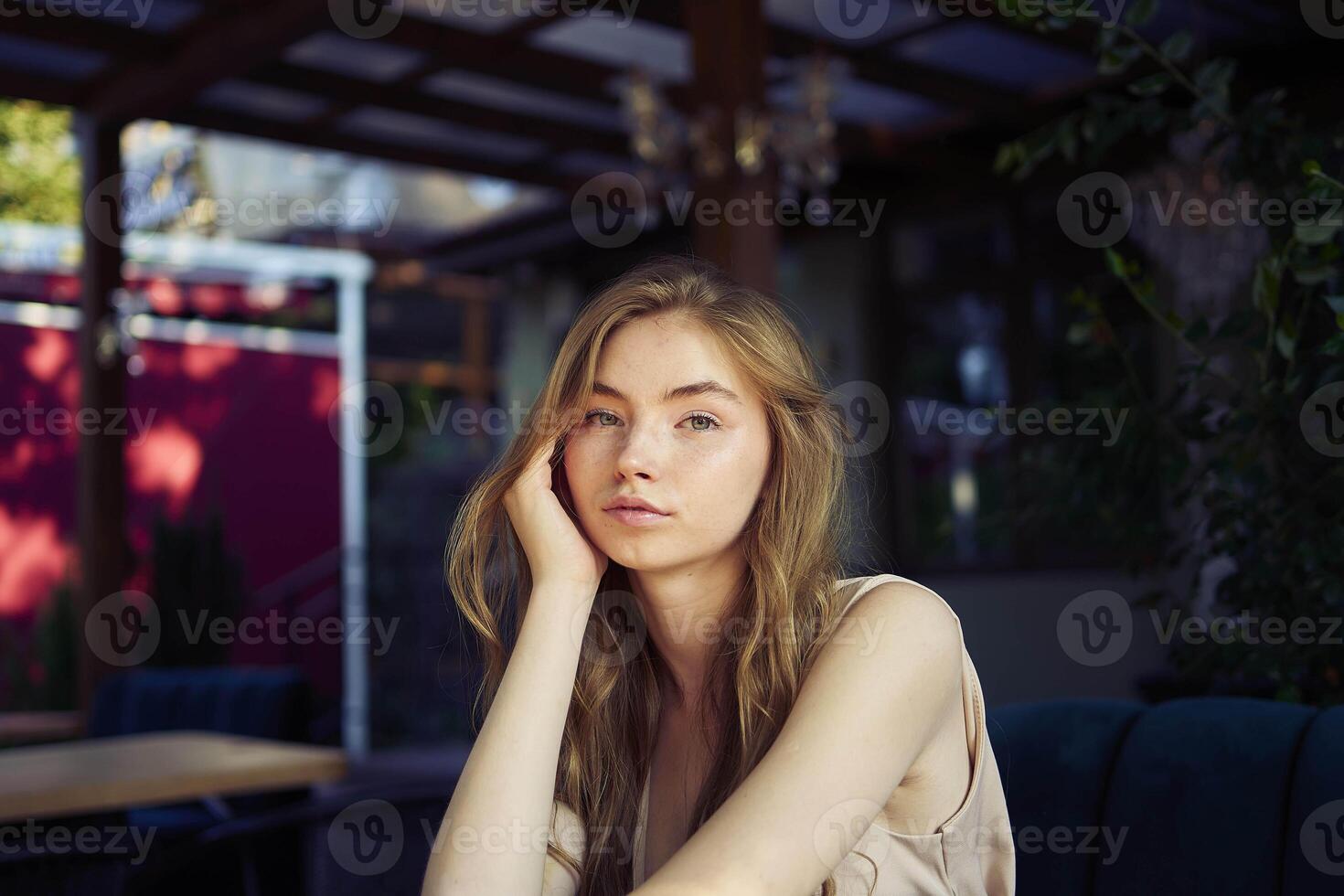 a beautiful teenage girl in a peach fuzz suit with a vest, in the old money style in a fancy restaurant photo