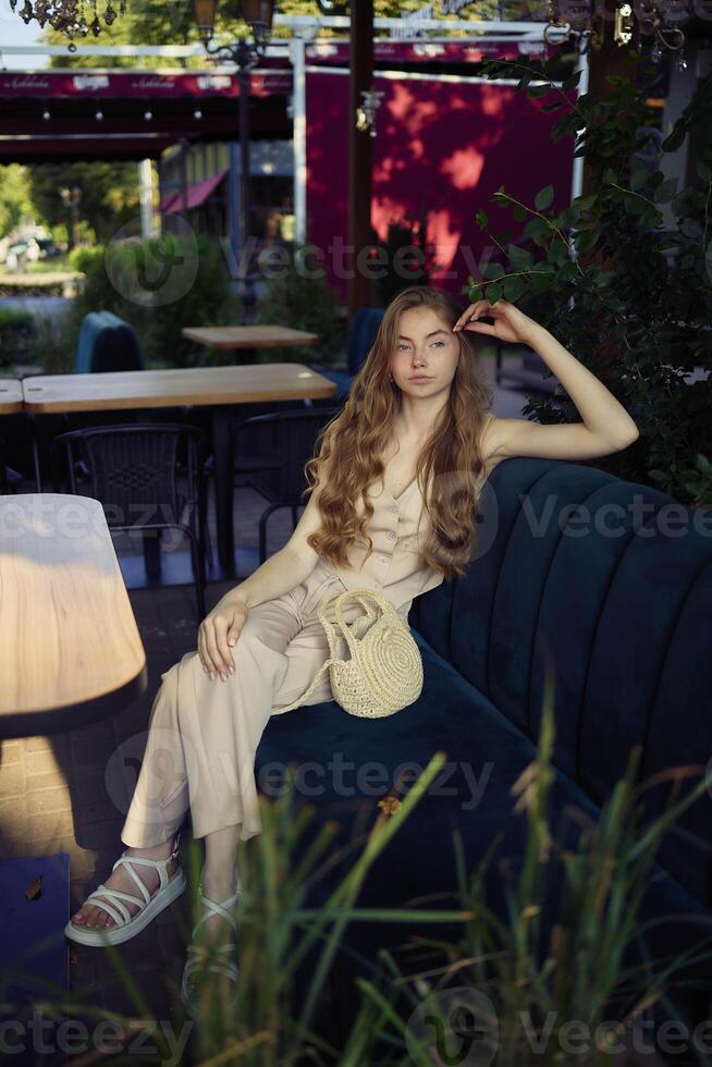 a beautiful teenage girl in a peach fuzz suit with a vest, in the old money style in a fancy restaurant photo