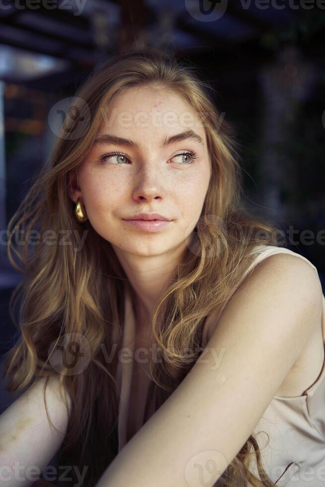 a beautiful teenage girl in a peach fuzz suit with a vest, in the old money style in a fancy restaurant photo