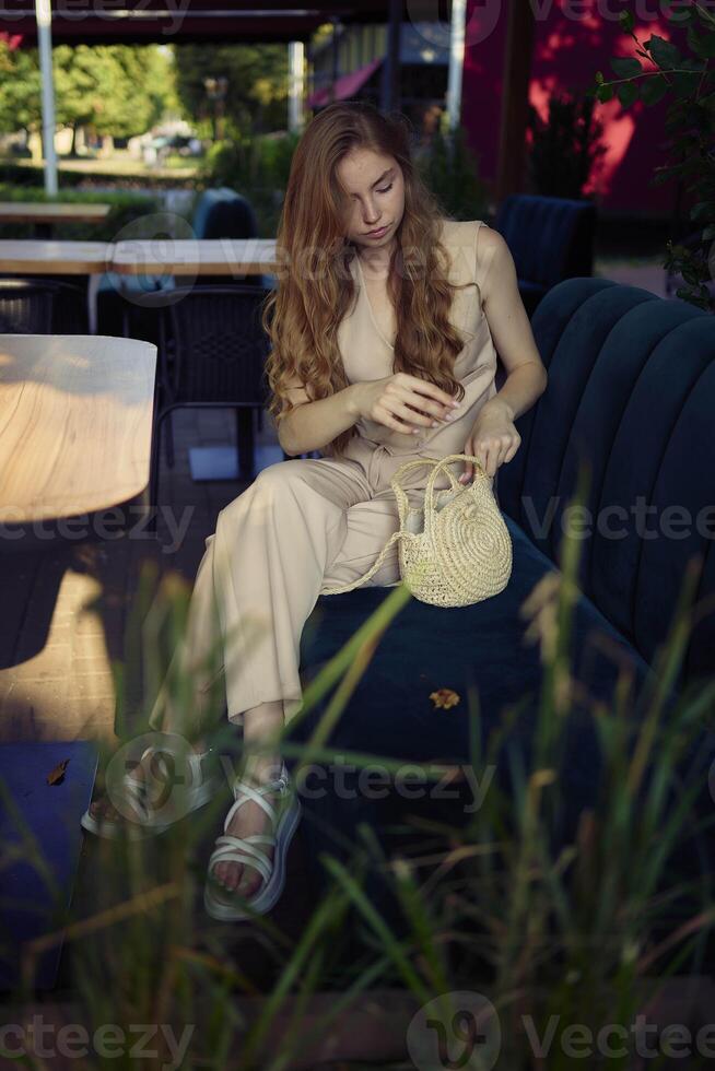 a beautiful teenage girl in a peach fuzz suit with a vest, in the old money style in a fancy restaurant photo