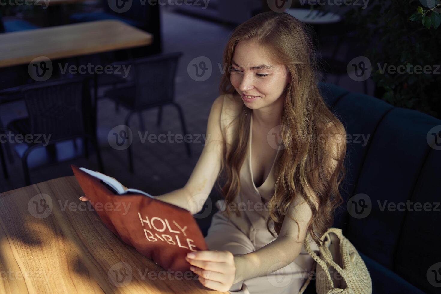 beautiful teenage girl in a peach fluffy suit with a waistcoat in the old money style reads the Holy Bible and prays photo