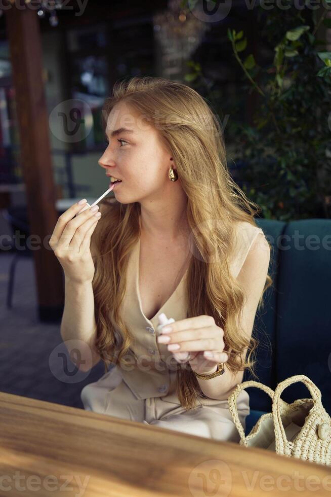 a beautiful teenage girl in a peach fuzz suit with a vest, in the old money style in a fancy restaurant photo