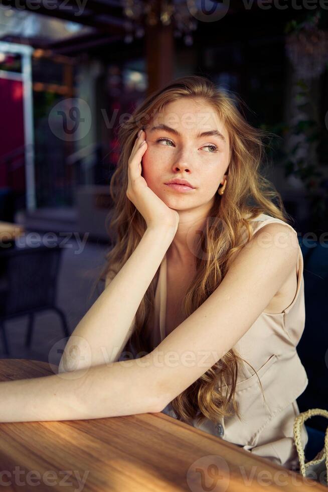 a beautiful teenage girl in a peach fuzz suit with a vest, in the old money style in a fancy restaurant photo
