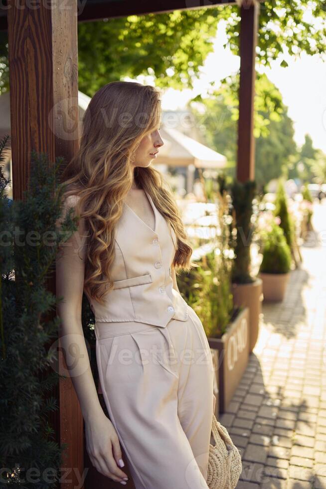 a beautiful teenage girl in a peach fuzz suit with a vest, in the old money style in a fancy restaurant photo