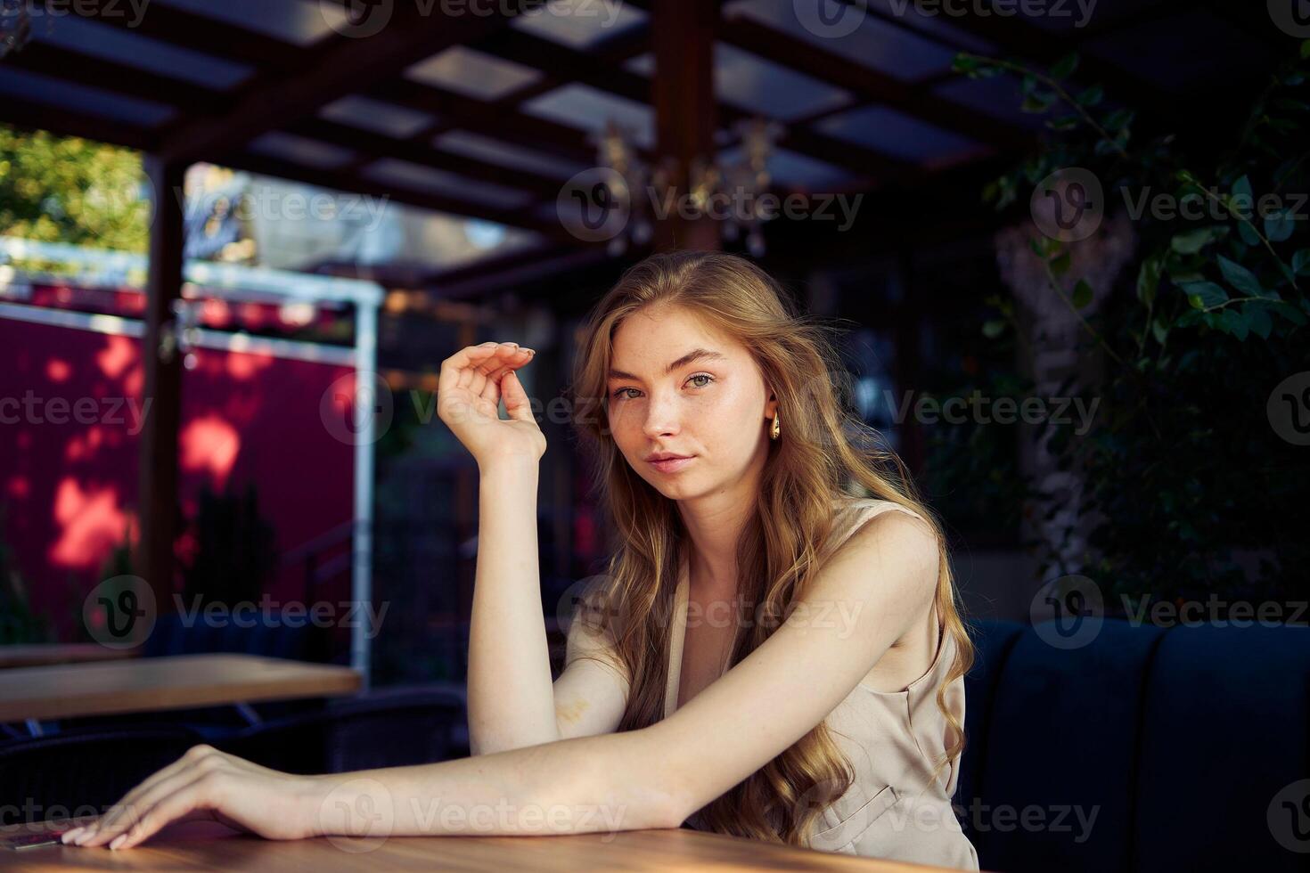 a beautiful teenage girl in a peach fuzz suit with a vest, in the old money style in a fancy restaurant photo