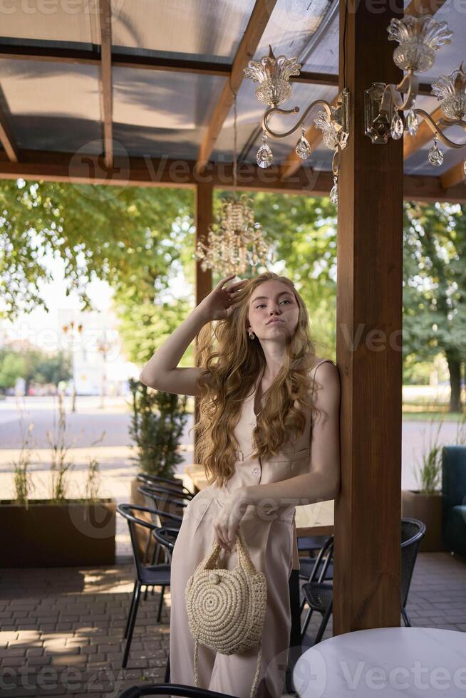 a beautiful teenage girl in a peach fuzz suit with a vest, in the old money style in a fancy restaurant photo
