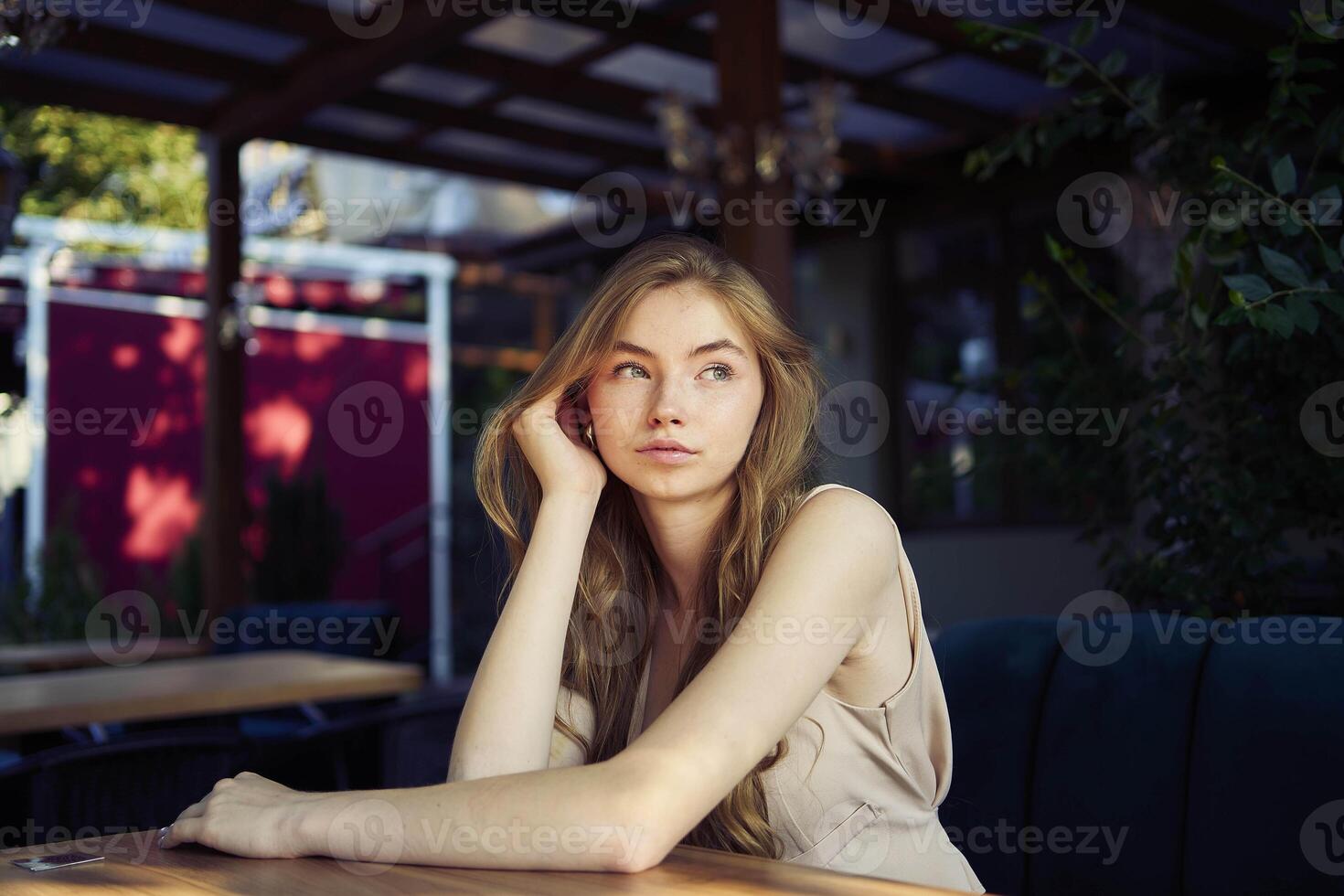 a beautiful teenage girl in a peach fuzz suit with a vest, in the old money style in a fancy restaurant photo