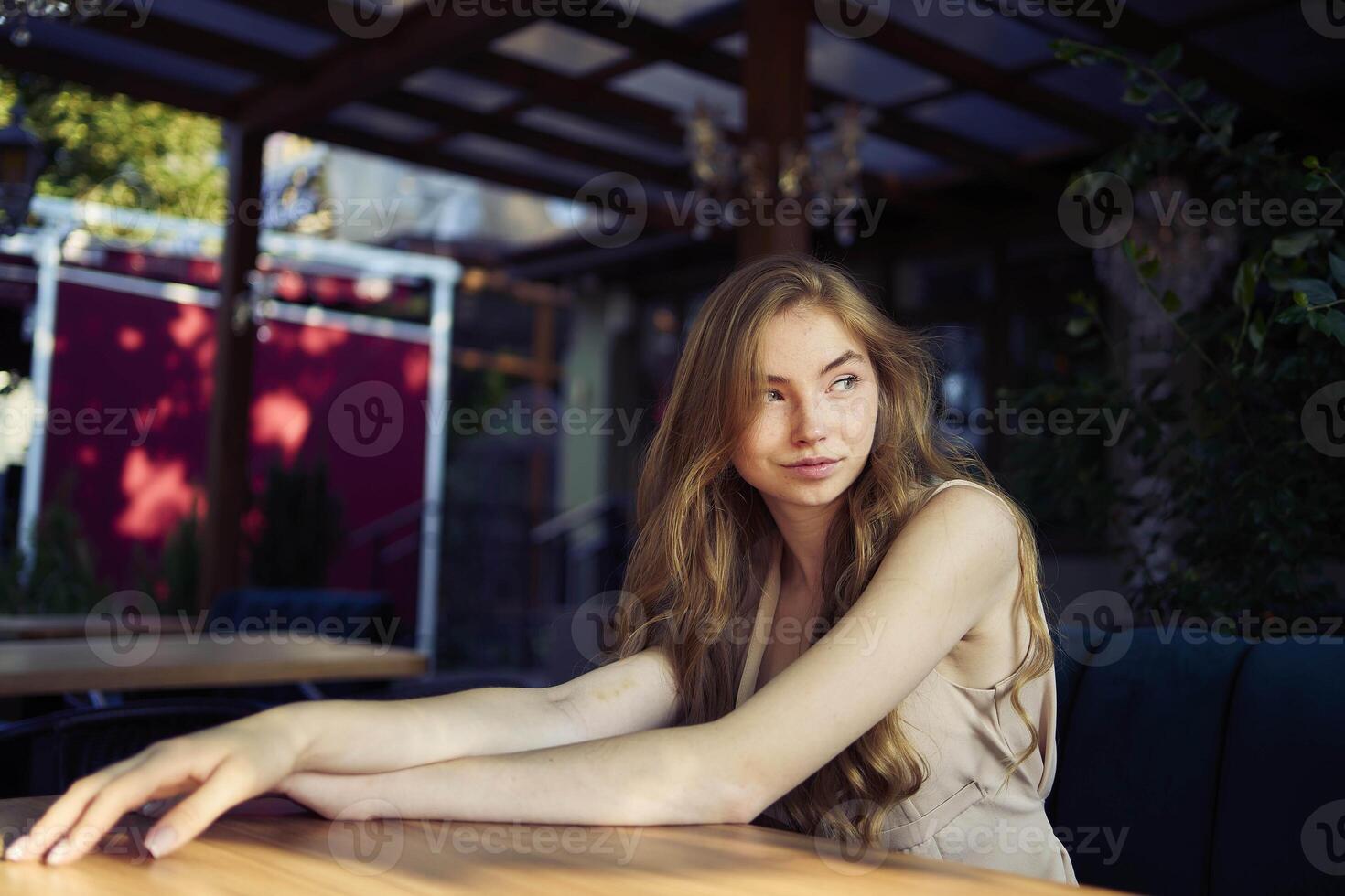 a beautiful teenage girl in a peach fuzz suit with a vest, in the old money style in a fancy restaurant photo