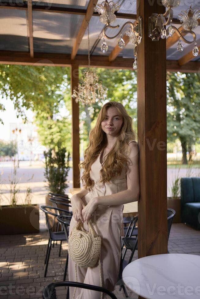 a beautiful teenage girl in a peach fuzz suit with a vest, in the old money style in a fancy restaurant photo