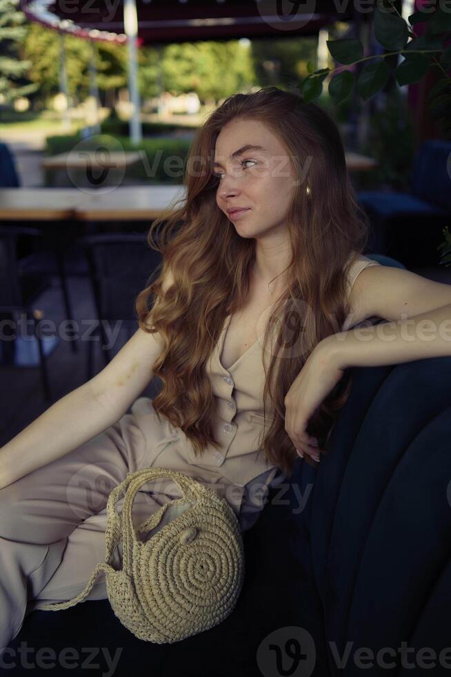 a beautiful teenage girl in a peach fuzz suit with a vest, in the old money style in a fancy restaurant photo