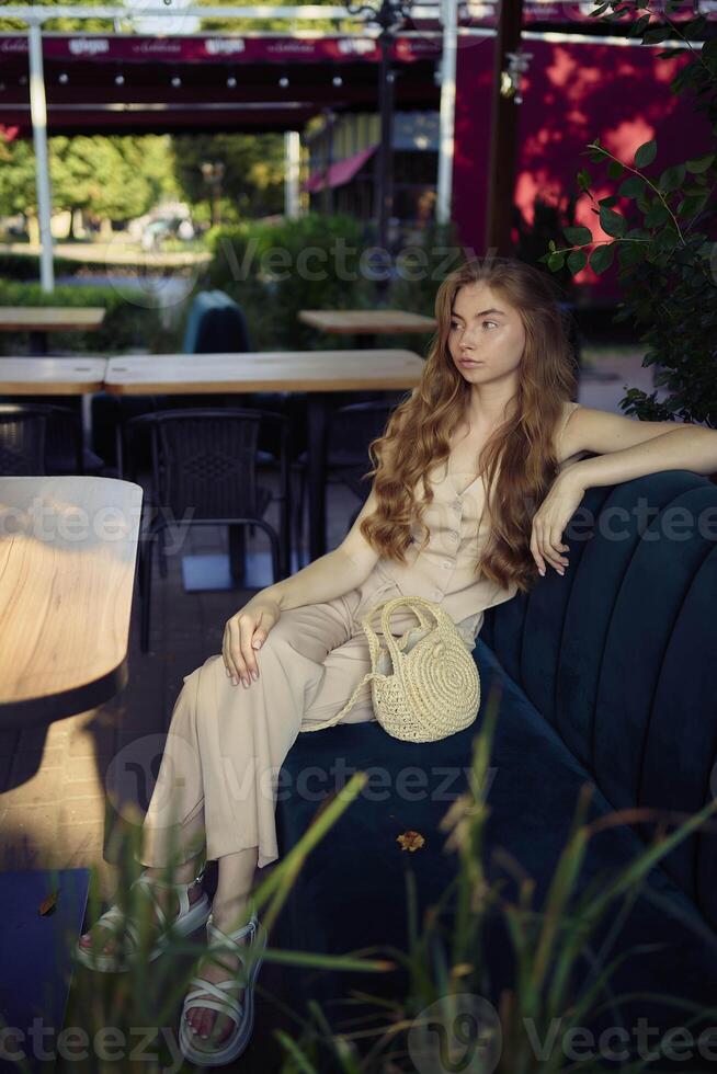 a beautiful teenage girl in a peach fuzz suit with a vest, in the old money style in a fancy restaurant photo