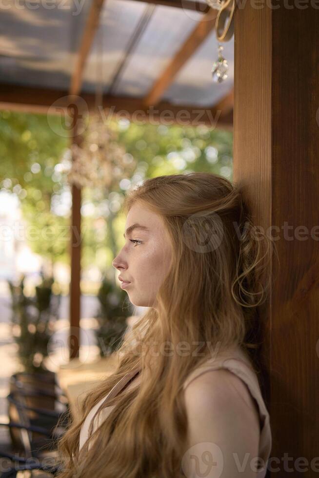 a beautiful teenage girl in a peach fuzz suit with a vest, in the old money style in a fancy restaurant photo