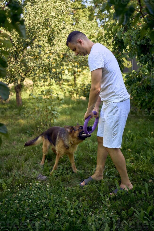 man playing with dog, tug toy, chew toy photo