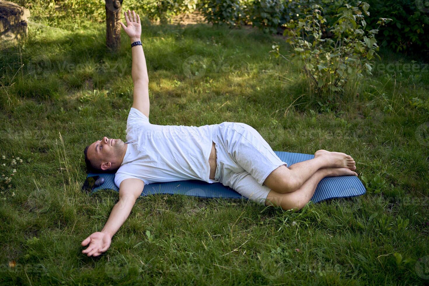 a man performs somatic exercises in the garden in the morning photo