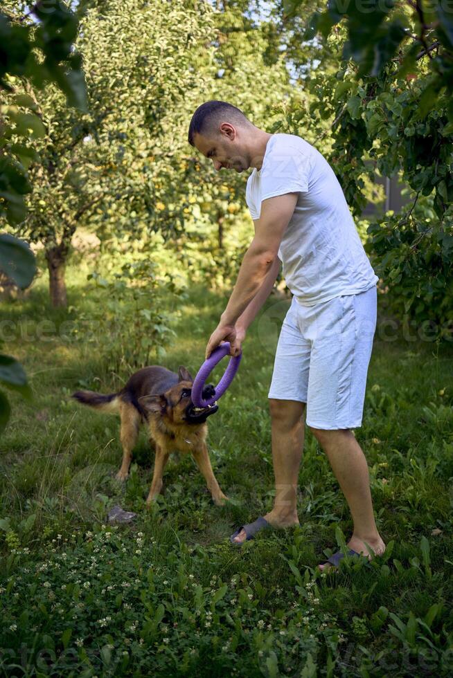 man playing with dog, tug toy, chew toy photo