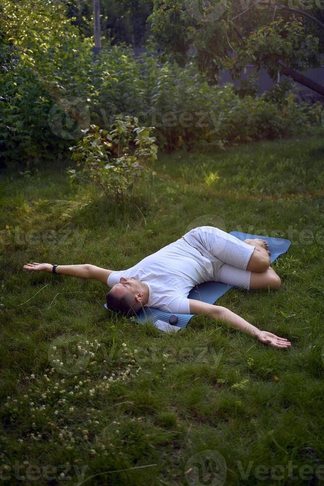 a man performs somatic exercises in the garden in the morning photo