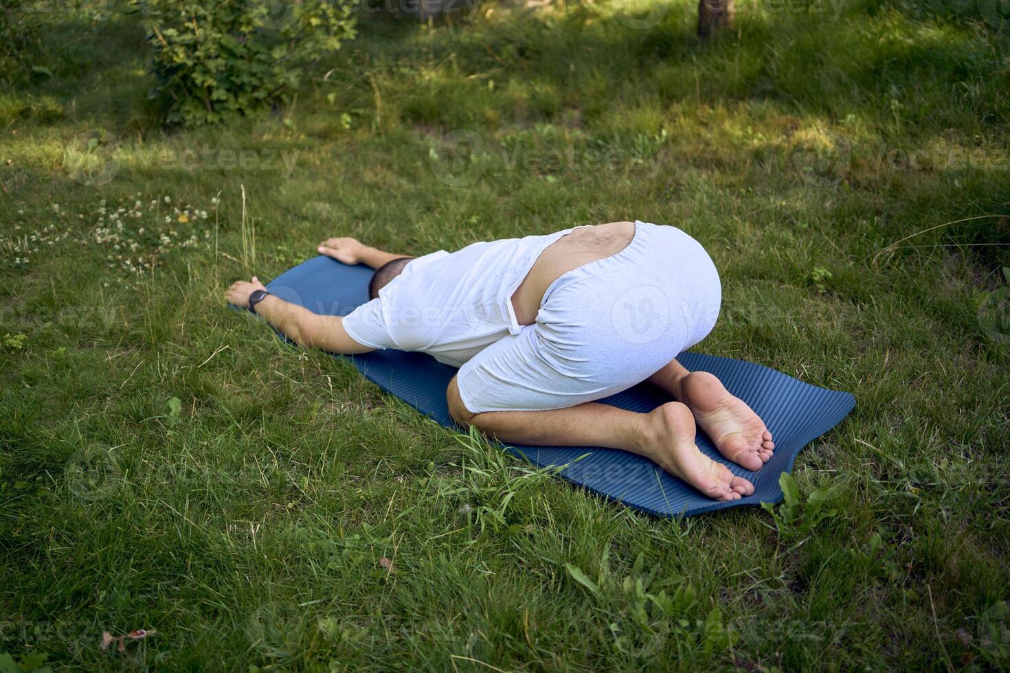 a man performs somatic exercises in the garden in the morning photo