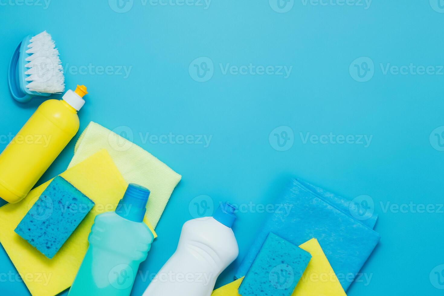 Cleaning kit detergents napkins sponges gloves, blue background. The concept of home cleaning or cleaning company services photo