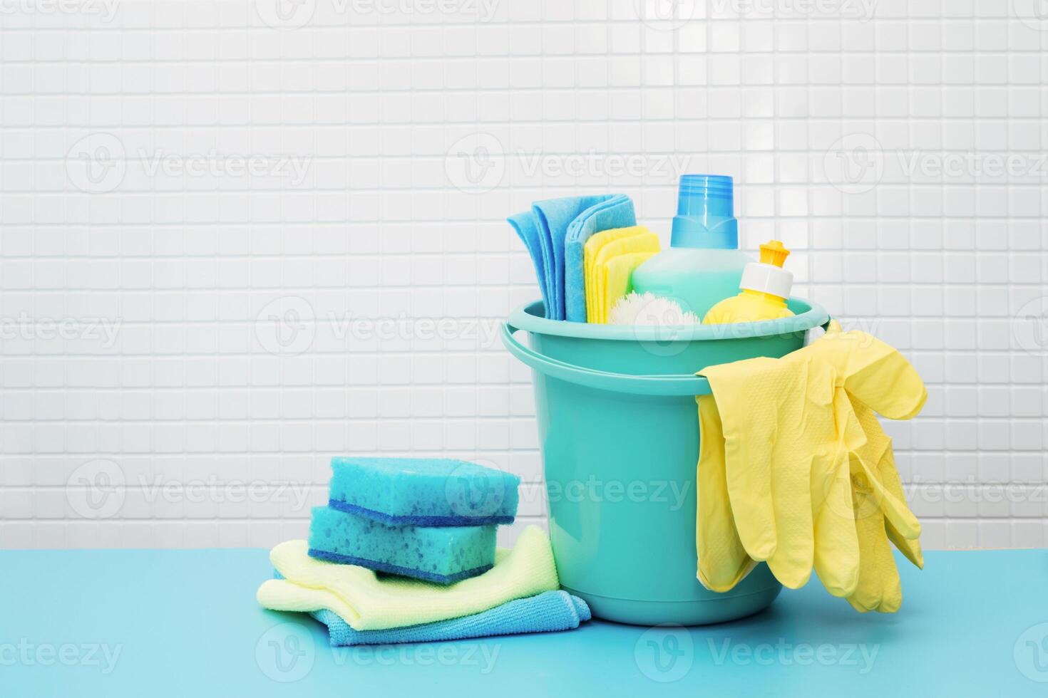Cleaners and detergents in bucket, accessories for cleaning various surfaces and rooms blue background photo
