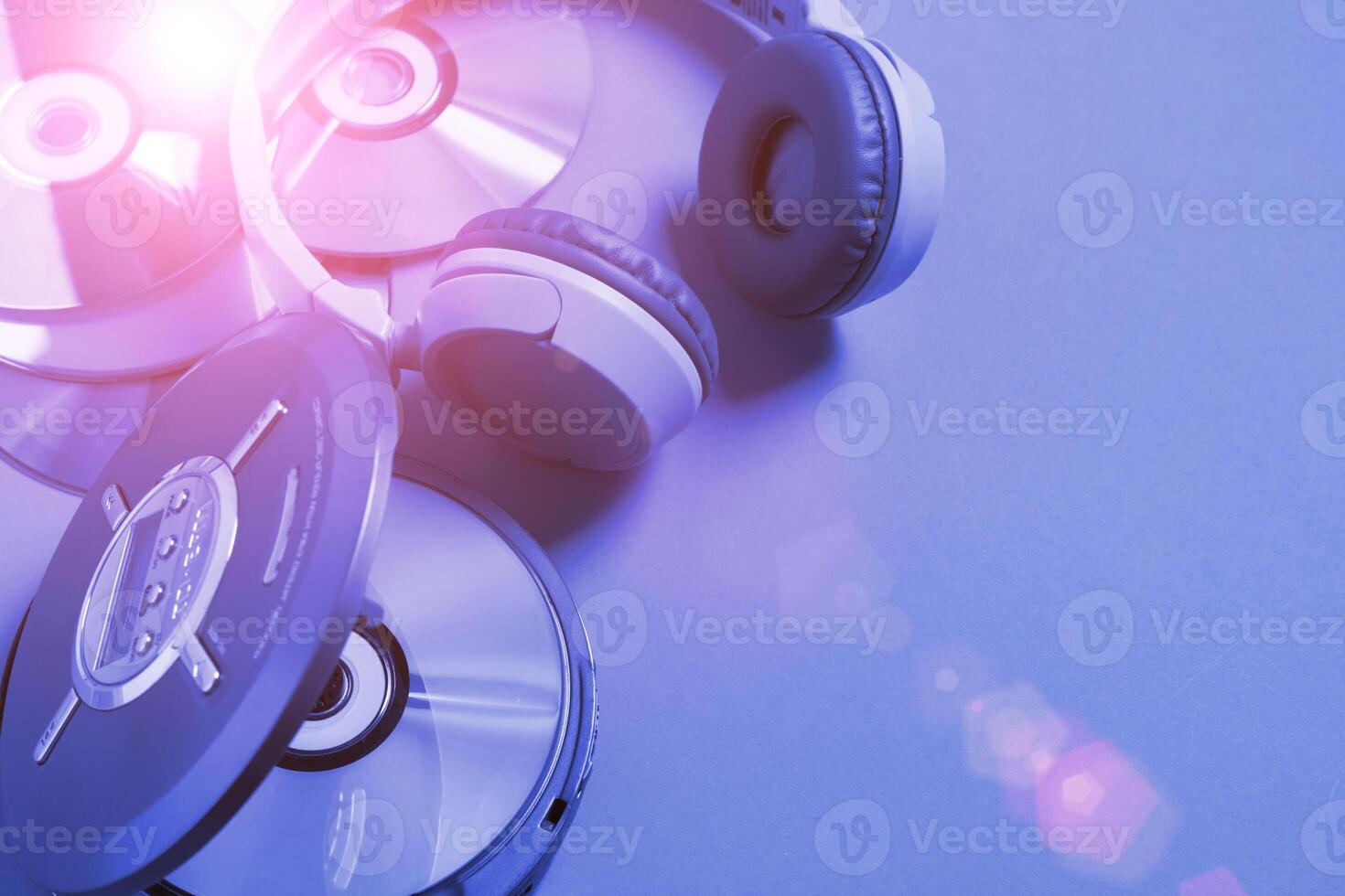 Personal compact portable CD player disks headphones blue neon background, Top view photo
