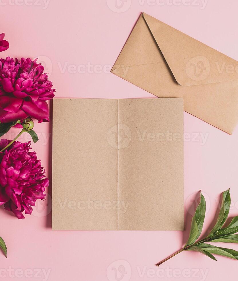 Blank paper beautiful burgundy peonies. Floral background top view flat layout. Frame of fresh flowers. Holiday concept. photo