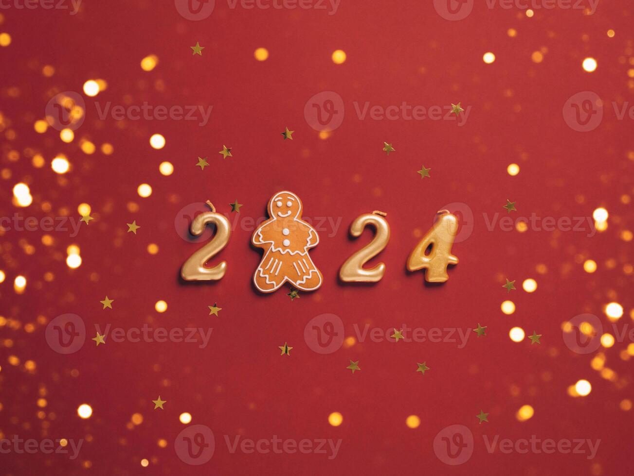 New year date numbers 2024 and gingerbread man cookies red festive background with confetti sparkles photo