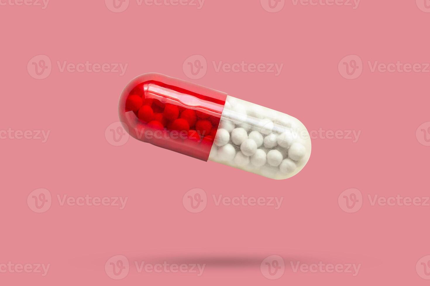 medicine capsule isolated on pink background photo