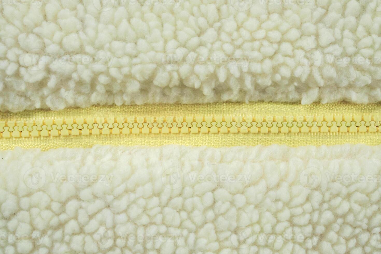 Yellow zipper on wool plush fleece fur fabric texture background photo