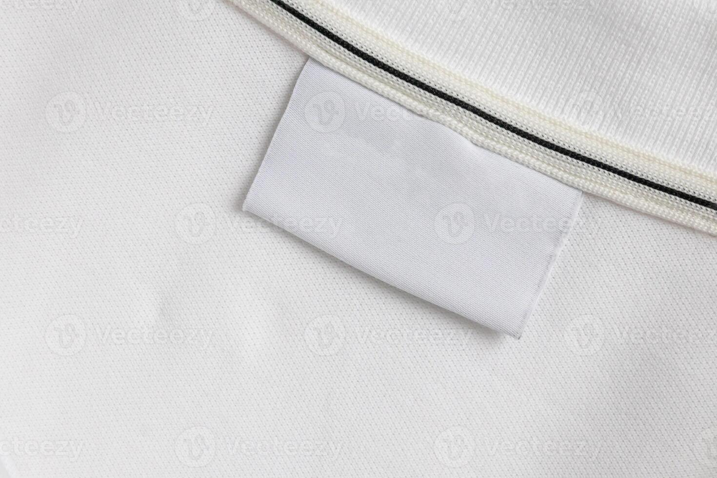 Blank white laundry care clothes label on white shirt fabric texture background photo
