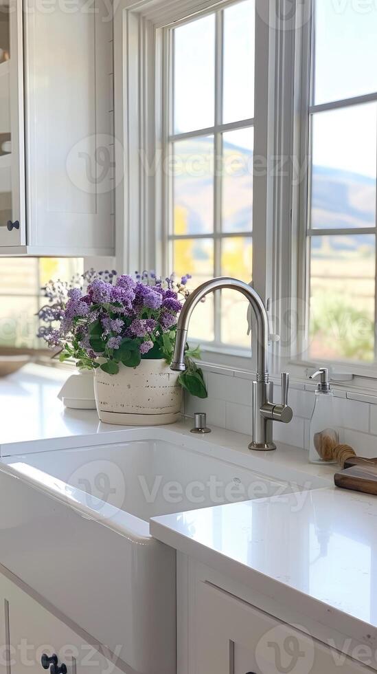 Beautiful kitchen sink with plants overlooking a picturesque landscape through large windows photo