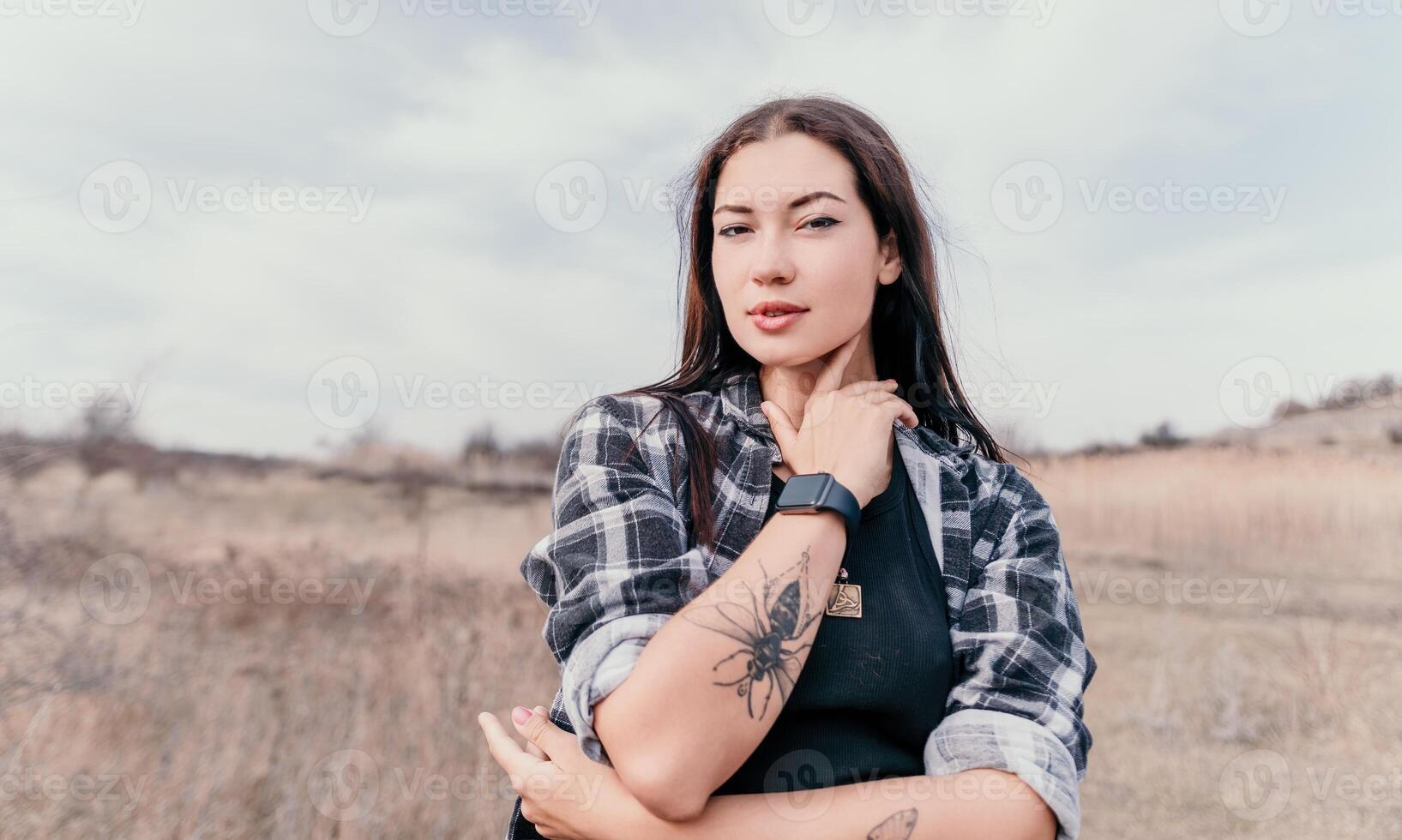 Happy young smiling woman with freckles outdoors portrait. Soft sunny colors. Outdoor close-up portrait of a young brunette woman and looking to the camera, posing against autumn nature background photo