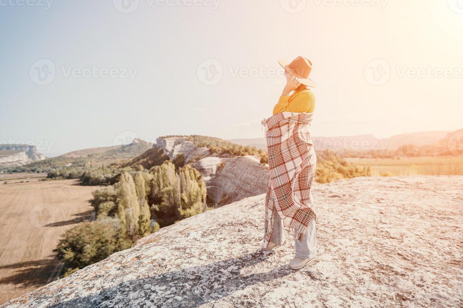 Woman in a Hat and Blanket Standing on a Mountaintop photo