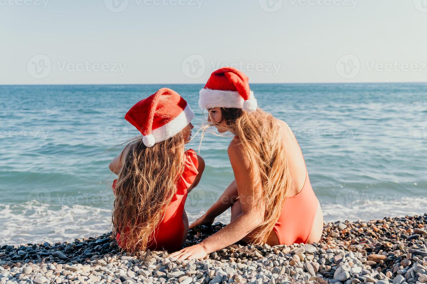 Christmas on the Beach. Two Women in Santa Hats photo
