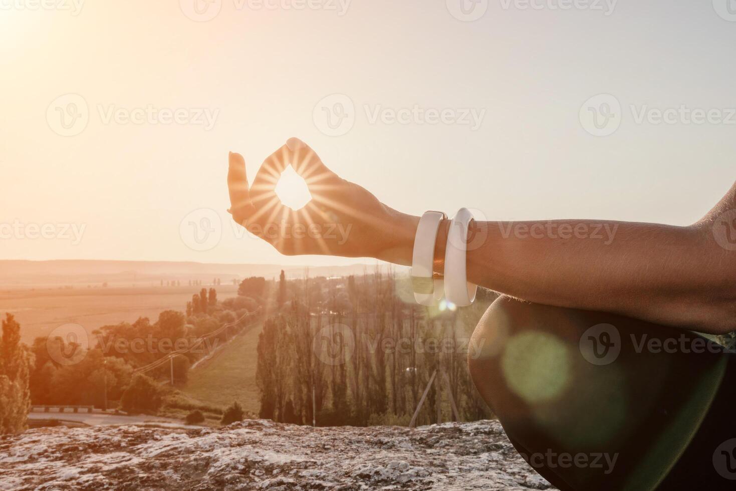 Fitness woman. Happy middle-aged fitness woman doing stretching and pilates on a rock near forest at sunset. Female fitness yoga routine. Healthy lifestyle with focus on well-being and relaxation. photo